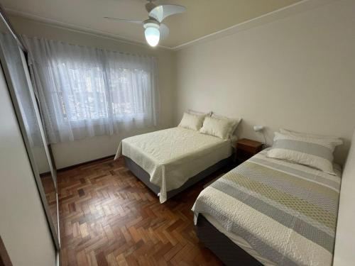 a bedroom with two beds and a window at Apartamento para 9 pessoas - Blumenhaus 201 - uma quadra da Rua Coberta! in Gramado