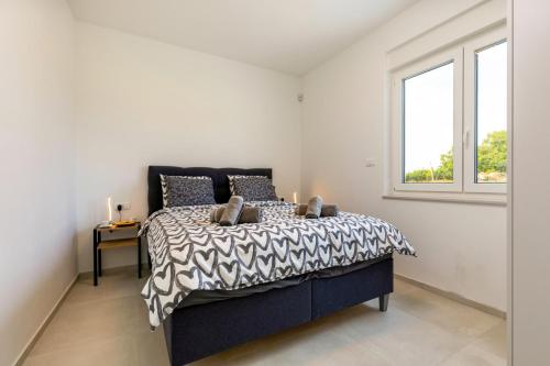 sypialnia z łóżkiem i oknem w obiekcie Villa Rosmarino by Villa Plus w mieście Grandići
