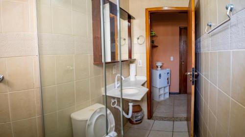 a bathroom with a toilet and a sink at Hotel Dellamares in Ubatuba