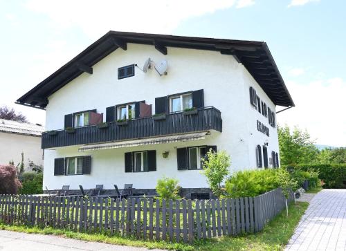 a white house with black windows and a fence at Enjoyit Velden West in Selpritsch