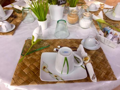 a table with a white tea kettle on a plate at Villa Franci in Santa Teresa Gallura