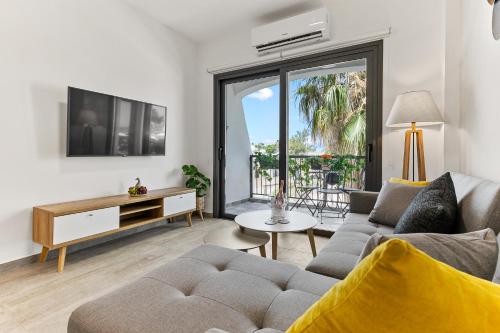a living room with a couch and a tv at Dreamy 2 bed apartment by the sea in Paphos