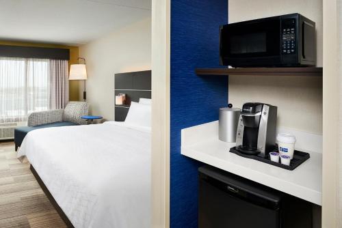 a hotel room with a bed and a tv at Holiday Inn Express & Suites Windsor East - Lakeshore by IHG in Lakeshore