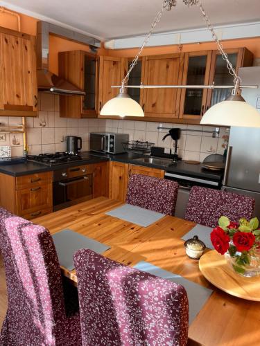 cocina con mesa de madera con sillas y comedor en Pokoje Gościnne Agata & Mikołaj, en Władysławowo