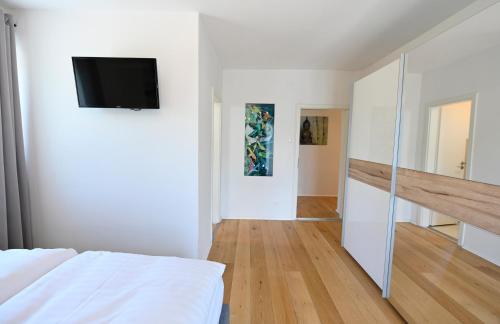 a bedroom with a bed and a tv on a wall at Enjoyit Velden West in Selpritsch