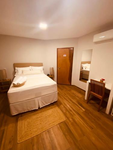 a bedroom with a white bed and a wooden floor at Beach Eco Stays Hotel Boutique Lagoinha in Tigre