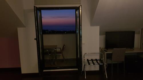 a room with a window and a desk and a television at Calas De Liencres in Liencres