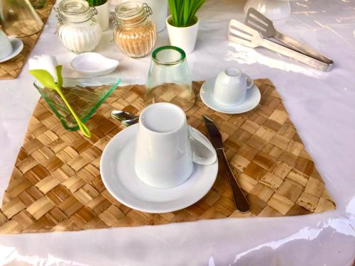 a table with white plates and cups on a table at Villa Franci in Santa Teresa Gallura