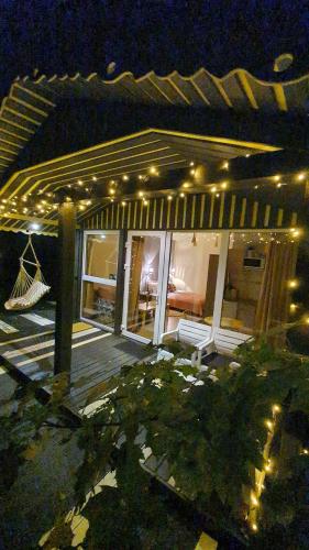 a house with a porch with lights on it at night at Kaimo turizmo sodyba Geras in Leliūnai