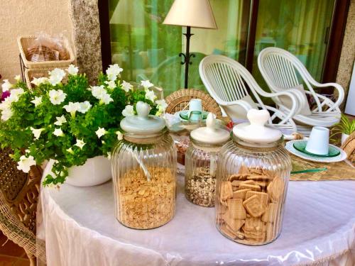 a table with jars of food and flowers on it at Villa Franci in Santa Teresa Gallura