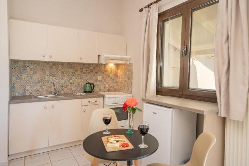 a kitchen with a table and two glasses of wine at Minas Apartments in Divarata
