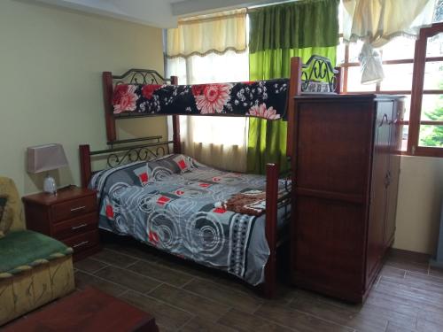 a bedroom with a bed and a bunk bed at Hospedaje Wiruyana in Cotacachi