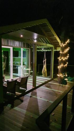 a patio with chairs and lights on a deck at night at Kaimo turizmo sodyba Geras in Leliūnai