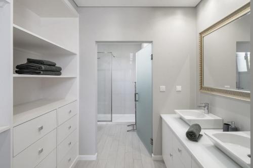 un bagno bianco con lavandino e specchio di Villa Old Town by Villa Plus a Funchal