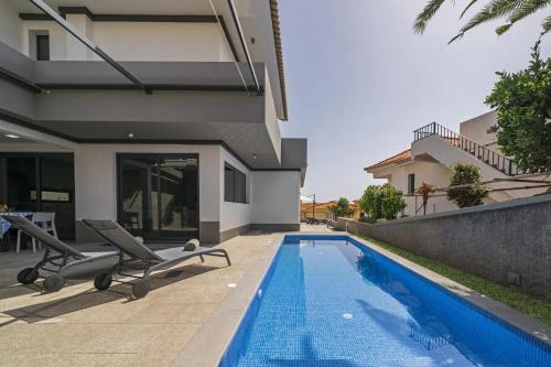 a swimming pool in front of a house at Villa Old Town by Villa Plus in Funchal