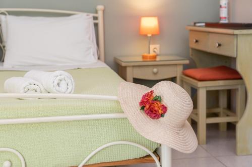 a bed with a hat with a flower on it at Minas Apartments in Divarata
