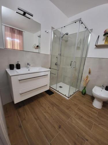 a bathroom with a glass shower and a sink at Casa Twins in Sassari