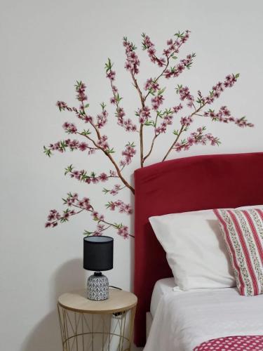 a bedroom with a tree mural on the wall at Casa Twins in Sassari