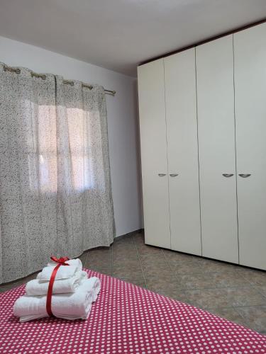 a room with white cabinets and a bed with a red blanket at Casa Twins in Sassari