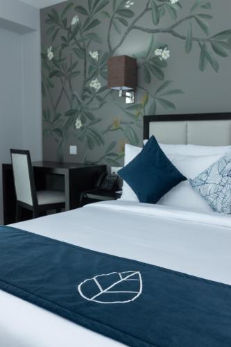 a bed with a blue blanket on top of it at MaRadha Colombo in Colombo