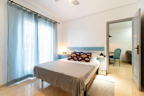 a bedroom with a large bed and a mirror at apartamento Sunrise Apolo in Torrevieja