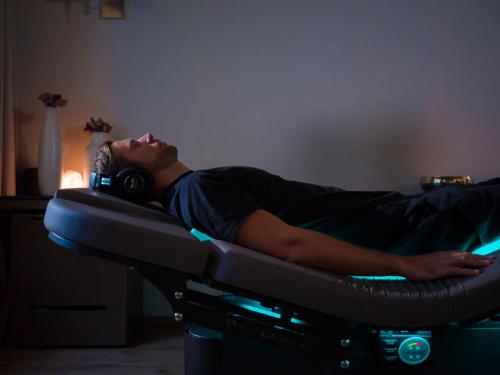a man laying on a bed wearing headphones at Cartesiano Boutique & Wellness Hotel in Puebla