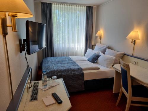 um quarto de hotel com uma cama e uma televisão em myMINGA13 - Hotel & serviced Apartments em Munique