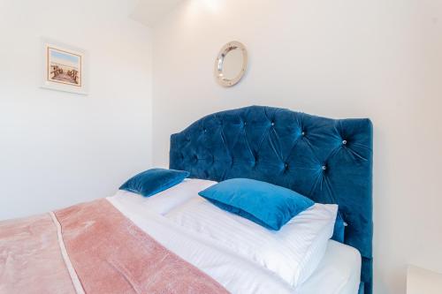 1 dormitorio con cama azul y almohadas azules en Apartament Rowerowo przez Mierzeję, rowery gratis, en Sztutowo
