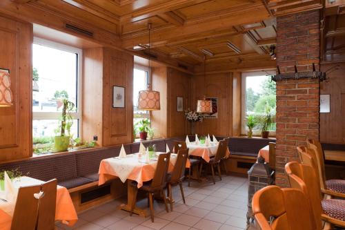 a dining room with tables and chairs and windows at Hotel Deutscher Hof in Babenhausen