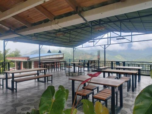 a restaurant with tables and chairs and a view of the mountains at Finca Campestre Villa del Campo in Santa Rosa de Cabal