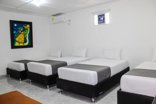 a group of four beds in a room at Hotel Poblado Suite in Barranquilla