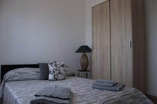 包內伊的住宿－Montecolcau Panoramic view，一间卧室配有带两个枕头和一盏灯的床