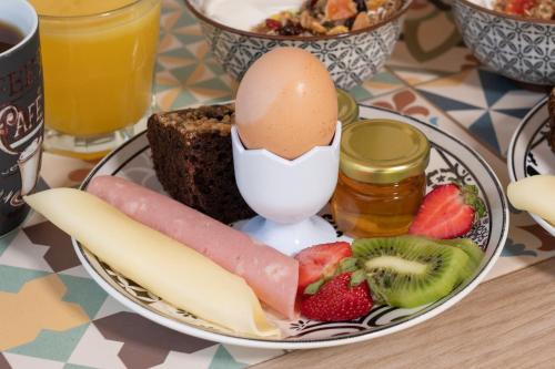 a plate of food with an egg and fruit at Minas Apartments in Divarata