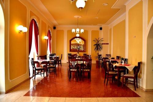 a dining room with tables and chairs in a restaurant at Hotel Astoria in Satu Mare