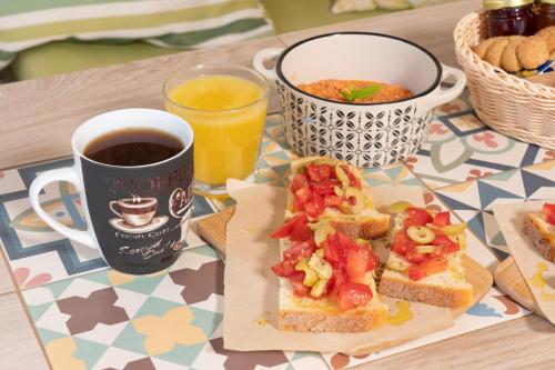 a table with a sandwich and a cup of coffee and a drink at Minas Apartments in Divarata