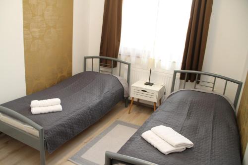 two beds in a small room with a window at Simon Vendégház Balatongyörök in Balatongyörök