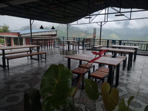 a restaurant with tables and chairs on a roof at Finca Campestre Villa del Campo in Santa Rosa de Cabal