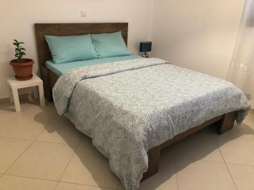 a bedroom with a bed with a blue comforter at Artemis House in Artemida