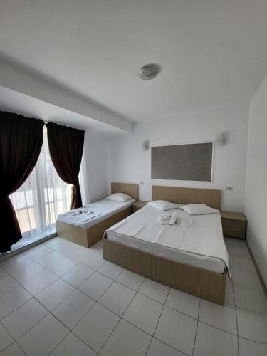a bedroom with two beds and a large window at Casa Sagrada in Eforie Nord