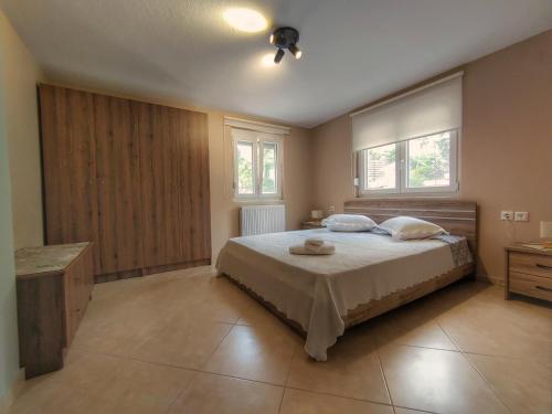 1 dormitorio con 1 cama grande y 2 ventanas en Stellar Blue Palio en PalaiónTsiflíkion