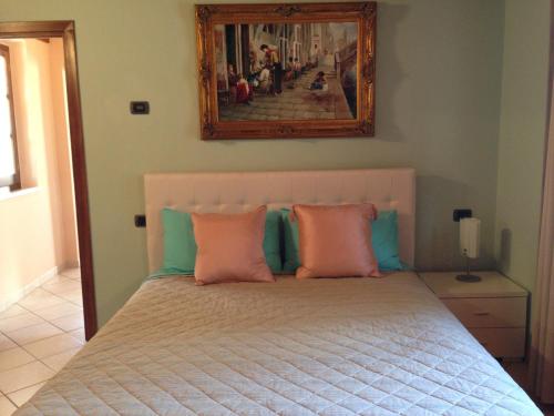 a bedroom with a bed with pink and blue pillows at Beautiful Tranquil Villa in Tuscany in Sarteano