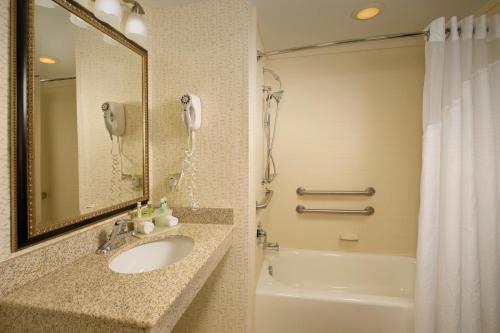 a bathroom with a sink and a phone next to a tub at Holiday Inn Express & Suites Columbia - East Elkridge, Jessup an IHG Hotel in Elkridge