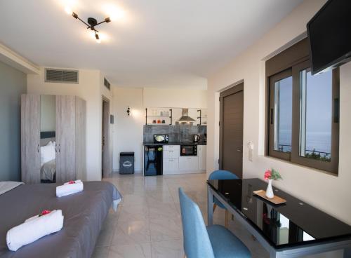 a room with a bed and a desk and a kitchen at MELIKIRON LUXURY APARTMENTS in Agios Nikitas