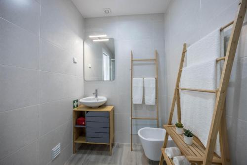 a bathroom with a sink and a mirror at Sunset Apartment in Sagres