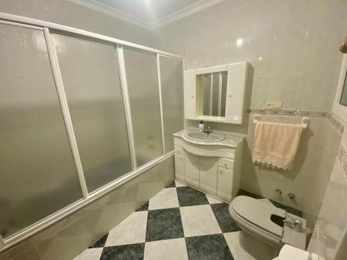 Un baño blanco con inodoro y lavabo. en Casa Nati, en Alfarnate