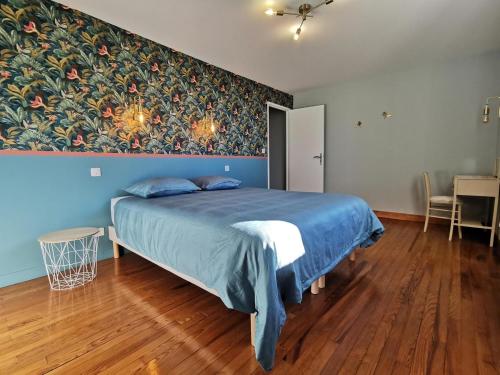 een slaapkamer met een bed met een schilderij aan de muur bij Gîte - Le Moussat in Lagraulet-du-Gers