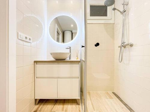 Baño blanco con lavabo y espejo en Apartament 'Es Botànic', en Blanes