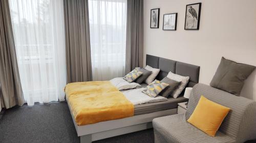 een slaapkamer met een bed, een bank en een stoel bij Apartament 301 Planeta in Mielno