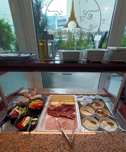a tray of food on a table with plates of food at Parizs Garden Apartments in Debrecen