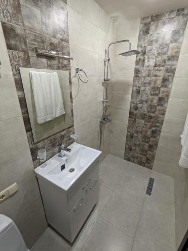 a white bathroom with a sink and a shower at Milky Way in Stepantsminda